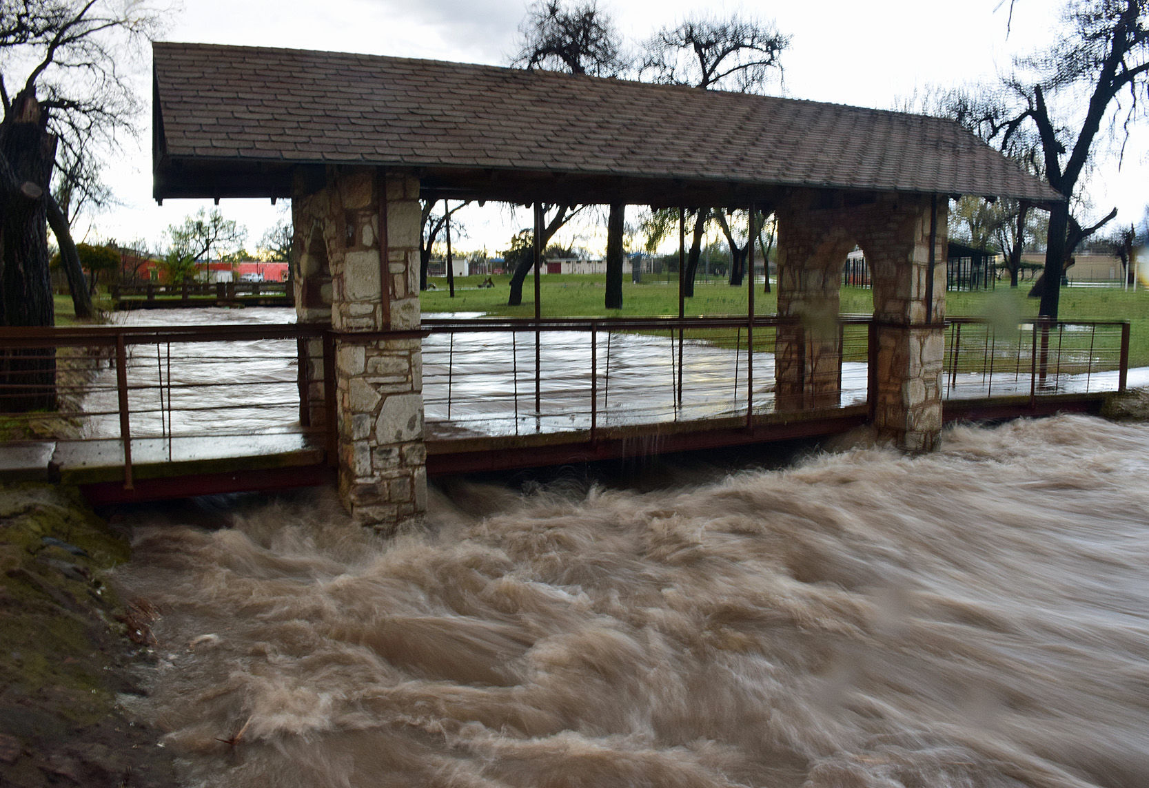 Rainwater rushes under bridge